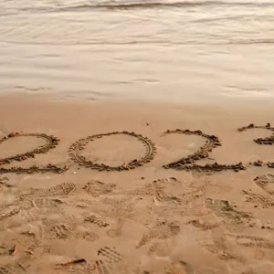 Picture of the Year 2023 carved in sand at a beach.